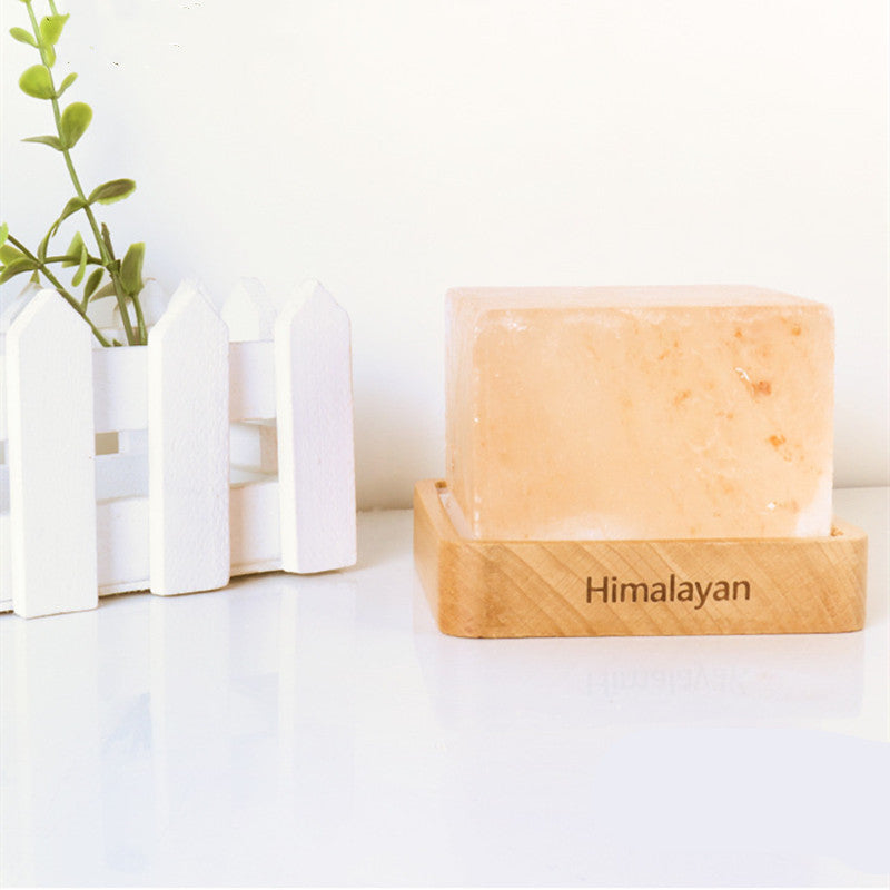 Salt Block Lamp on Table - A lamp made from natural salt crystals, emitting a warm and soothing glow, perfect for adding a touch of natural radiance to your space.