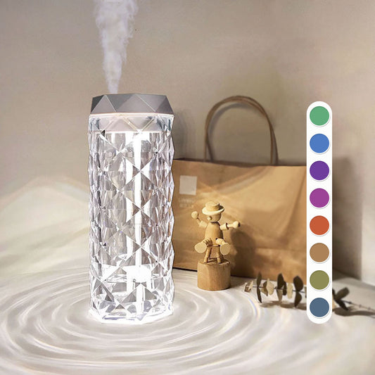 Elegant Air Humidifier Crystal Lamp emitting a soothing mist to improve air quality, paired with a warm, ambient light that glows through its crystal-like structure. The lamp is displayed on a wooden surface, highlighting its modern design and dual functionality as both a humidifier and a decorative lamp.