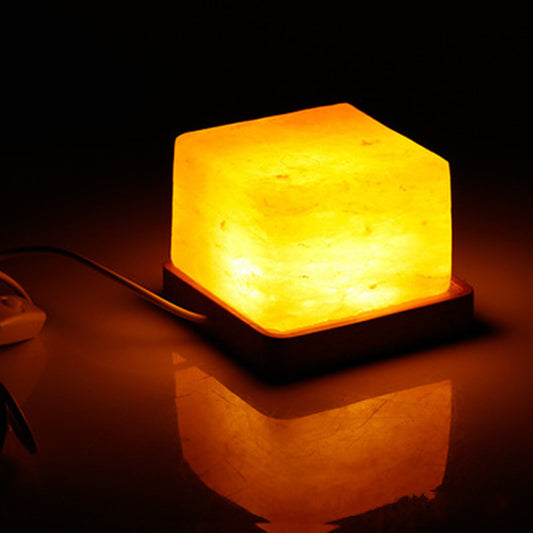 Salt Block Lamp on Table - A lamp made from natural salt crystals, emitting a warm and soothing glow, perfect for adding a touch of natural radiance to your space.