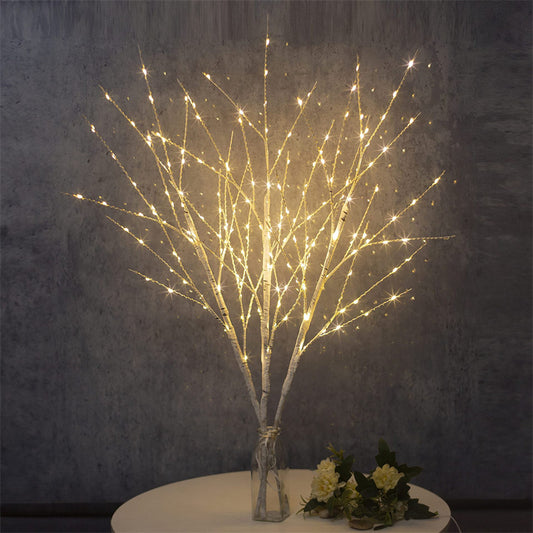 Beautiful LED Birch Branch illuminated with warm white lights, adding a cozy and festive touch to any room. The branch is displayed against a neutral background, showcasing its natural birch texture and the soft glow of the LED lights.