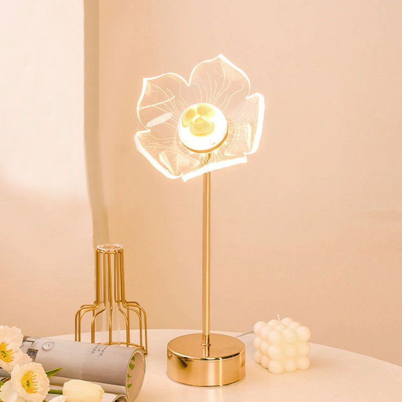 Charming Fairy Table Lamp featuring a delicate design with fairy silhouette cutouts, casting a warm and whimsical pattern of light and shadows when illuminated. The lamp is displayed on a wooden table, enhancing its magical and enchanting appeal.